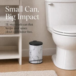 Compact white marble three liter step trash can placed beside a toilet in a clean neutral bathroom, keeping the space tidy and clutter free.