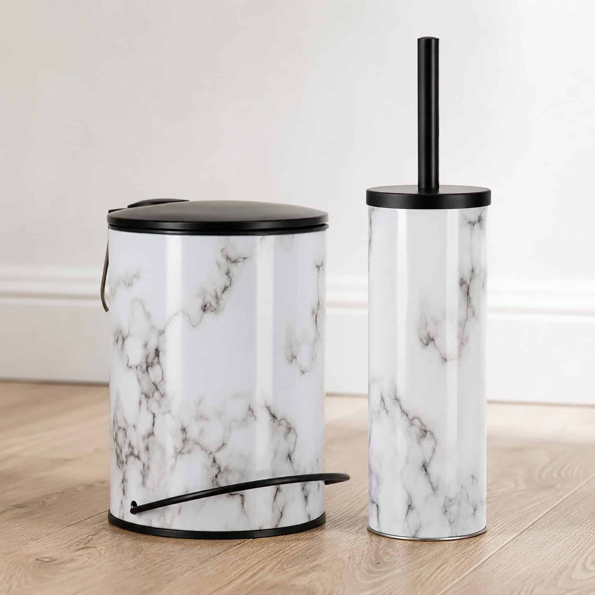 Coordinated marble bathroom set with a matching step trash can and toilet brush holder side by side, glossy white bodies with matte black lids.