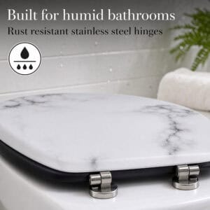 White marble toilet seat with rust resistant stainless steel hinges, built for humid bathrooms, shown closeup with water droplets on tile behind it.