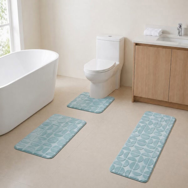 Light blue 3-piece bath rug set displayed in a modern bathroom with freestanding tub, toilet and wood vanity.