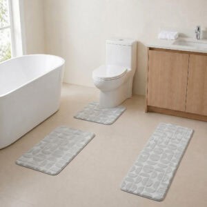 Light gray 3-piece bath rug set displayed in a modern bathroom with freestanding tub, toilet and wood vanity.