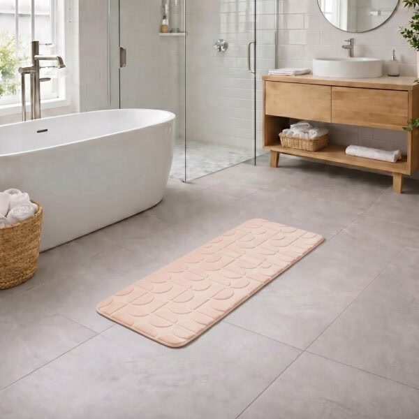 Blush pink long bathroom runner placed between bathtub and vanity in a modern bathroom with light tile floor and natural daylight, soft plush comfort along the entire length