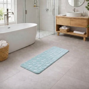 Light blue long bathroom runner placed between bathtub and vanity in a modern bathroom with light tile floor and natural daylight, soft plush comfort along the entire length