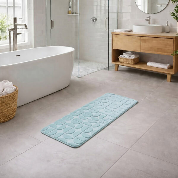 Light blue long bathroom runner placed between bathtub and vanity in a modern bathroom with light tile floor and natural daylight, soft plush comfort along the entire length