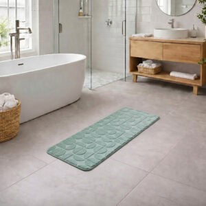Sage green long bathroom runner placed between bathtub and vanity in a modern bathroom with light tile floor and natural daylight, soft plush comfort along the entire length