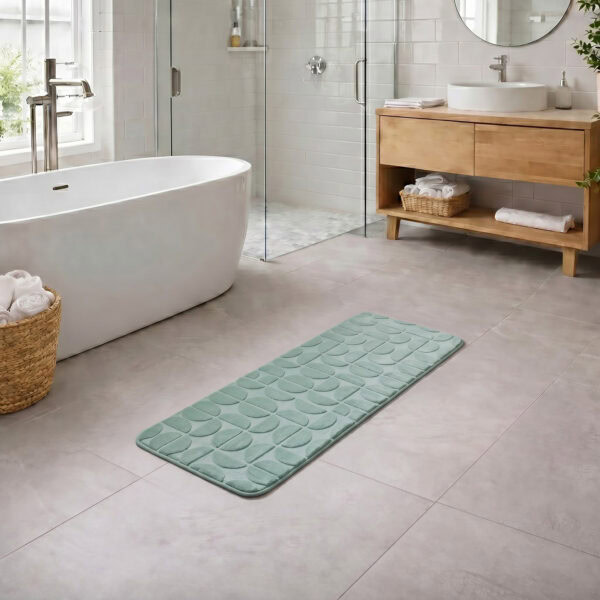 Sage green long bathroom runner placed between bathtub and vanity in a modern bathroom with light tile floor and natural daylight, soft plush comfort along the entire length