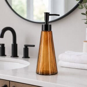 Amber glass soap dispenser styled on a modern white bathroom vanity with matte black faucet and round mirror