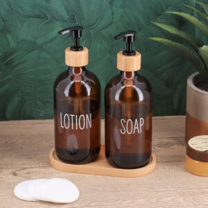 Amber glass soap and lotion dispenser set with bamboo accents in a bohemian bathroom setting