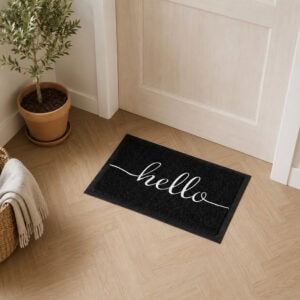 Hello doormat on light oak herringbone floor in Scandinavian entryway near olive tree and woven basket, indoor home accent
