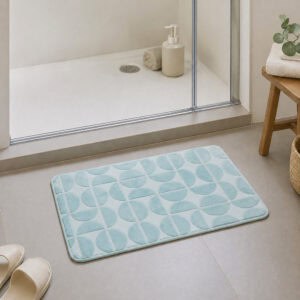 Light blue plush bath mat at the exit of a walk-in glass shower, modern Scandinavian bathroom with light tile floor and natural daylight, soft landing after every shower