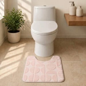 U-shape blush pink bath mat in a minimalist spa-style bathroom with stone tile floor and natural sunlight