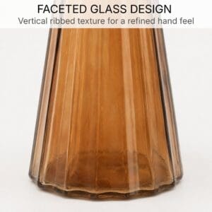 Close-up of the vertical ribbed faceted texture on the amber glass soap dispenser body and base