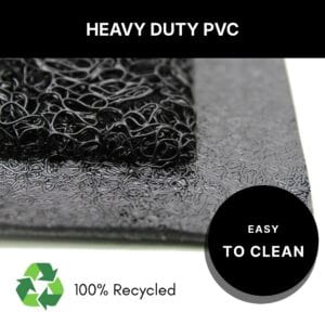 Corner detail of the black welcome doormat showing thick heavy-duty PVC construction, made from 100 percent recycled material and easy to clean with water