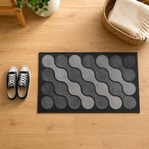 Gray ripple pattern rubber doormat in modern Scandinavian indoor entryway with light oak wood floor, sneakers and woven basket, top down view