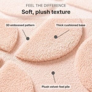 Close-up macro view of blush pink bath mat texture showing 3D embossed half-circle pattern, plush velvet-feel pile and thick cushioned memory foam base for ultimate softness underfoot