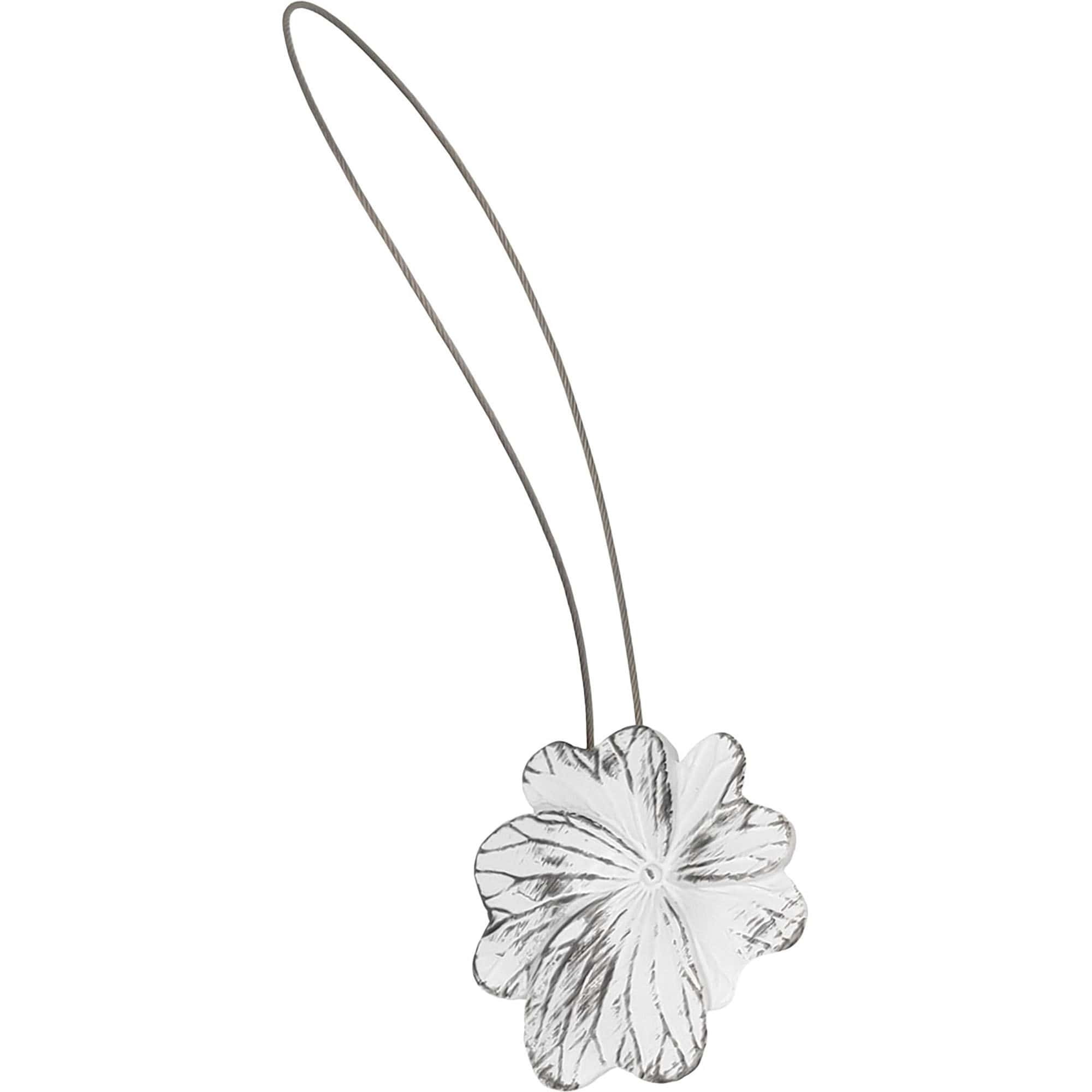 01 (hero packshot): Distressed white and black metal flower curtain tieback with a thin silver cable loop, shown against a plain background to highlight the carved petal detail.