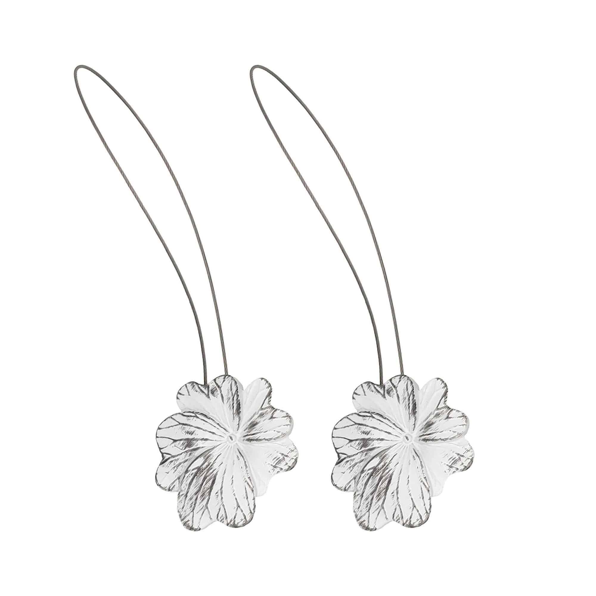 01 (set-of-2 packshot): Set of two distressed white and black metal flower curtain tiebacks with thin silver cable loops, shown against a plain background to highlight the carved petal detail.