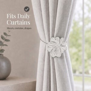 07 (fits daily curtains): White flower tieback gathering a greige linen curtain by a window, suited to everyday sheers, curtains, and drapes in a calm neutral setting.