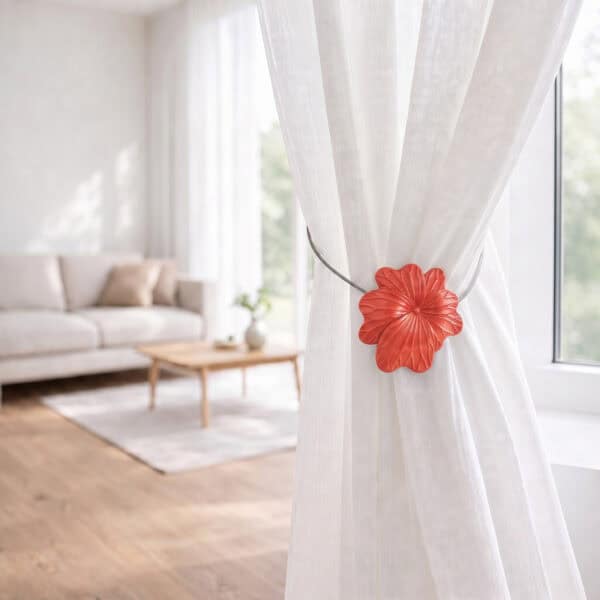 08 (living room lifestyle): Sheer white curtain held back by the terracotta flower tieback in a bright living room with a neutral sofa and wood coffee table softly blurred behind.