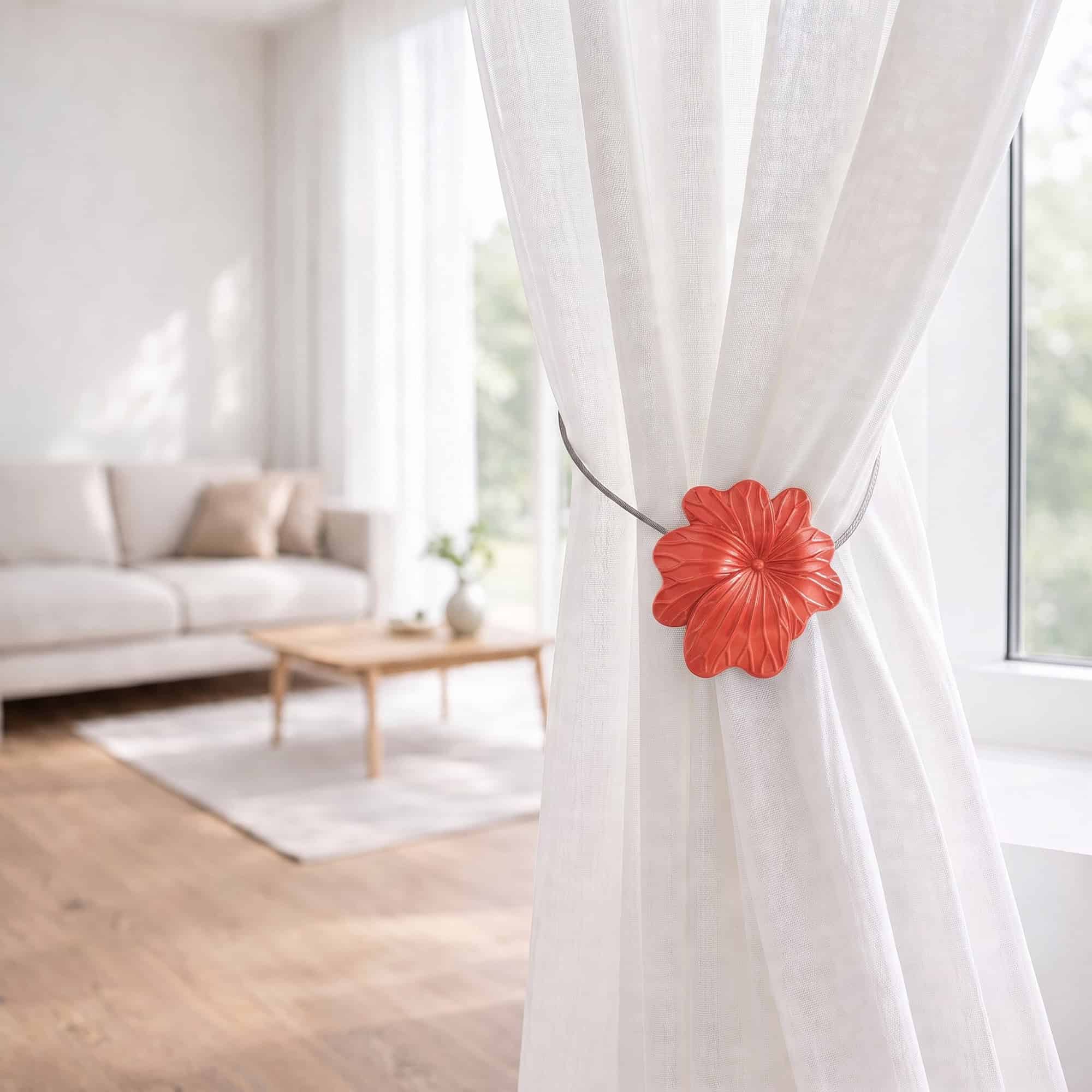 08 (living room lifestyle): Sheer white curtain held back by the terracotta flower tieback in a bright living room with a neutral sofa and wood coffee table softly blurred behind.