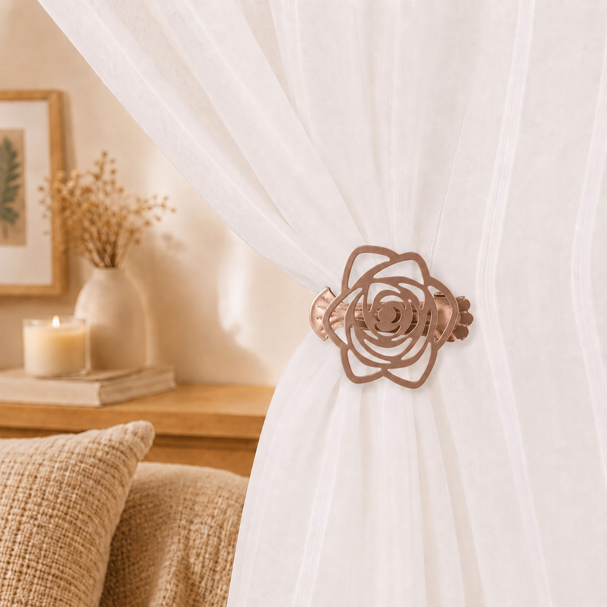 Close-up lifestyle view of a copper rose-shaped curtain clip-on holdback gathering a delicate white sheer curtain in a cozy bedroom setting, with a candle and vase in the background.