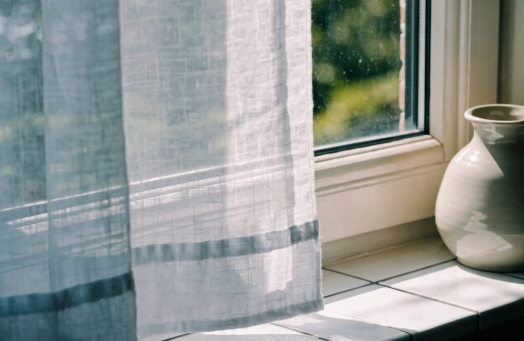 Light sheer cotton curtain letting daylight into a kitchen window